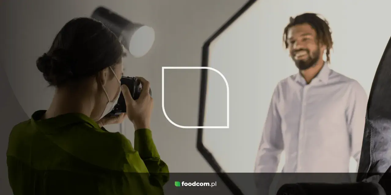 Fotógrafa toma fotos para CV de un hombre sonriente.