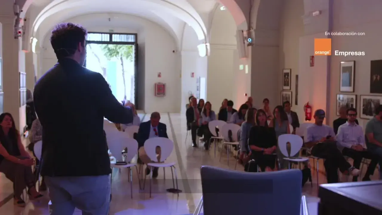 Ponente habla a audiencia en evento sobre empresas de inteligencia artificial, patrocinado por Orange Empresas.