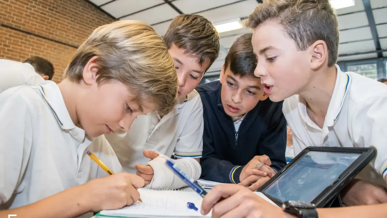 Chicos colaboran en un proyecto, usando tablet y cuaderno. Sus metodologías de aprendizaje son variadas y efectivas.