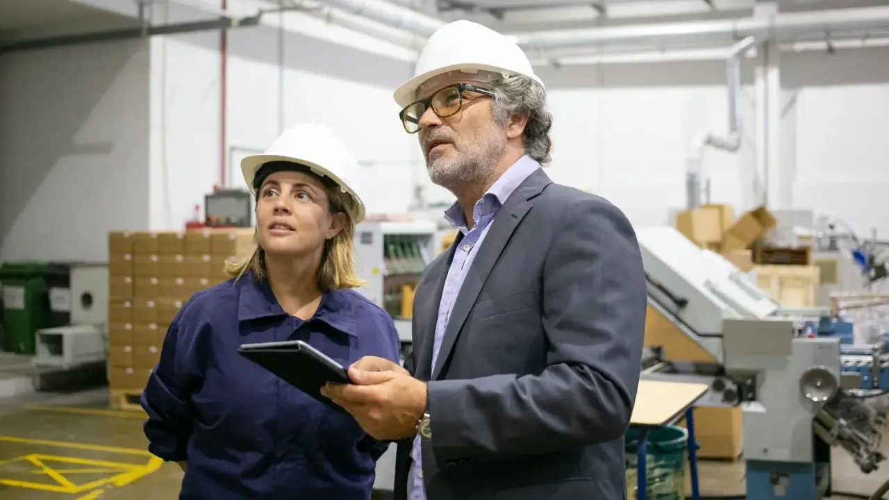 Supervisor de producción y su colega revisan el proceso en una fábrica.