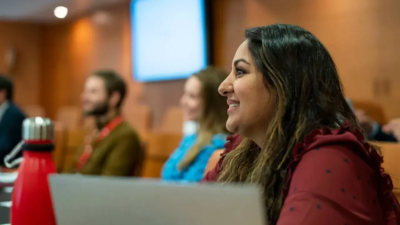 Mujer sonríe en clase del PDG IESE.