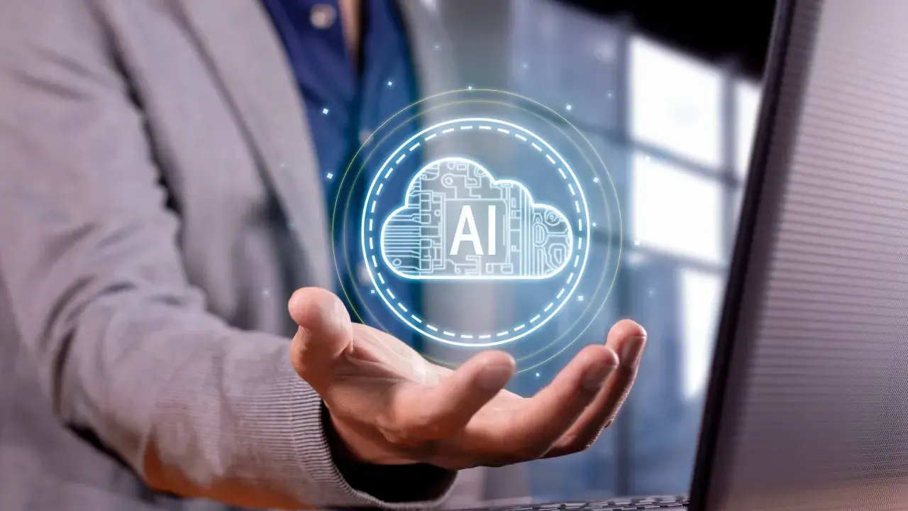 Un hombre con traje sostiene una nube digital con "AI" en su mano, representando los servicios en la nube para empresas.