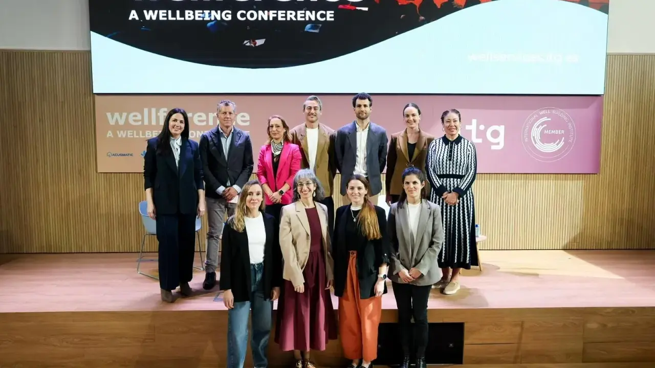 Grupo posa en el escenario de la conferencia "wellference", con el logo de ntp 639 visible.