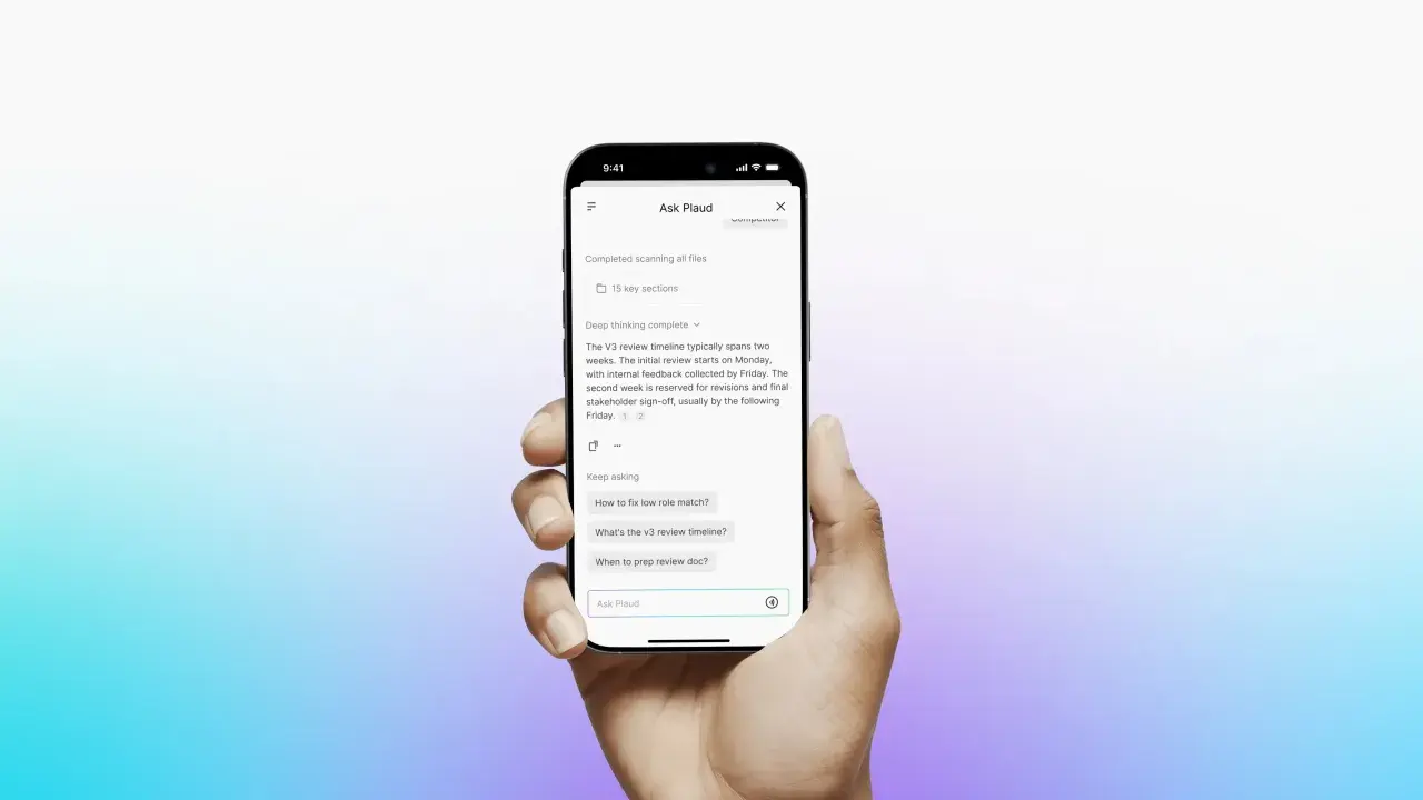Mano sosteniendo un teléfono con la app "Ask Plaud". Se ven preguntas para romper el hielo como "¿Cómo arreglar la coincidencia de roles?" y "¿Cuándo preparar el documento de revisión?".