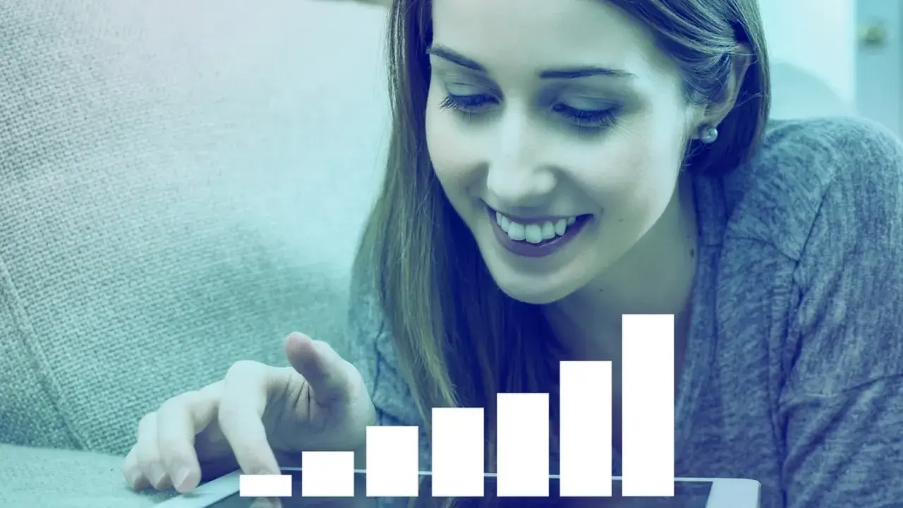 Mujer sonríe mientras interactúa con una tablet que muestra un gráfico de barras ascendente, simbolizando el liderazgo transformacional y el crecimiento.