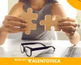 Manos unen piezas de rompecabezas de madera, simbolizando la integración en unas prácticas profesionales exitosas.