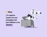 Un hombre reflexiona frente a su computadora, pensando en la **client communication** y cómo fidelizar clientes.