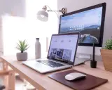 Escritorio moderno con laptop y monitor, ideal para un master business administration online.