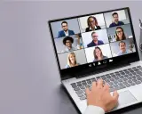 Persona interactúa con tecnología de videoconferencia, mostrando una cuadrícula de participantes en una reunión virtual.