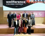 Grupo posa en el escenario de la conferencia "wellference", con el logo de ntp 639 visible.