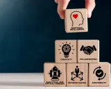 Bloques de madera apilados muestran habilidades blandas: inteligencia emocional, creatividad, colaboración, pensamiento analítico, toma de decisiones y adaptabilidad.