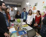 Equipo en una **stand up meeting** discutiendo ideas frente a un tablero lleno de notas adhesivas.