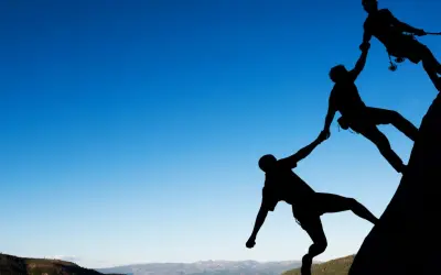 Siluetas de escaladores ayudándose mutuamente en una roca. Un ejemplo de cómo comportarse en el trabajo: colaboración y apoyo.