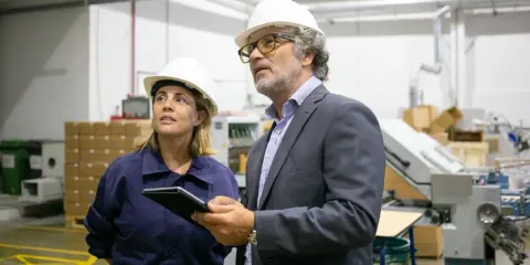 Supervisor de producción y su colega revisan el proceso en una fábrica.