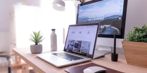 Escritorio moderno con laptop y monitor, ideal para un master business administration online.