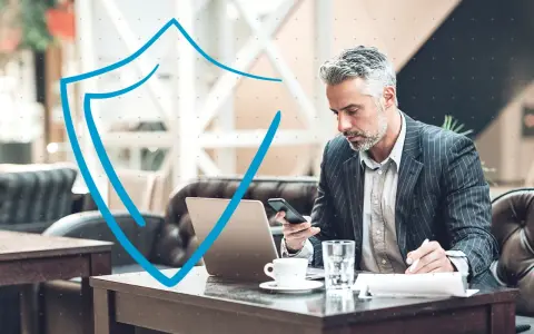 Hombre de negocios con portátil y móvil, trabajando en la nube con seguridad.