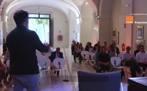 Ponente habla a audiencia en evento sobre empresas de inteligencia artificial, patrocinado por Orange Empresas.