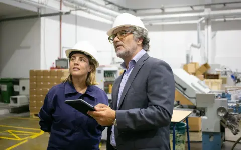Supervisor de producción y su colega revisan el proceso en una fábrica.