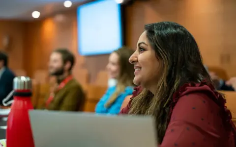 Mujer sonríe en clase del PDG IESE.