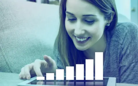 Mujer sonríe mientras interactúa con una tablet que muestra un gráfico de barras ascendente, simbolizando el liderazgo transformacional y el crecimiento.