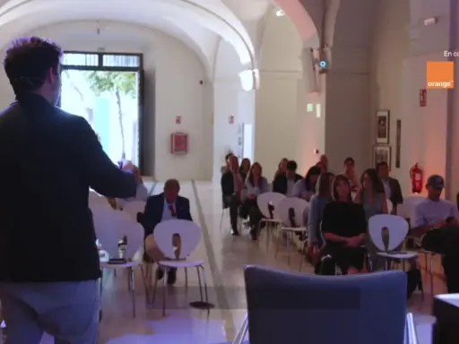 Ponente habla a audiencia en evento sobre empresas de inteligencia artificial, patrocinado por Orange Empresas.