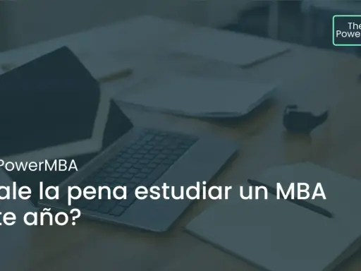 Un portátil y un cuaderno abierto sobre un escritorio, con el texto "¿Vale la pena estudiar un MBA este año?".