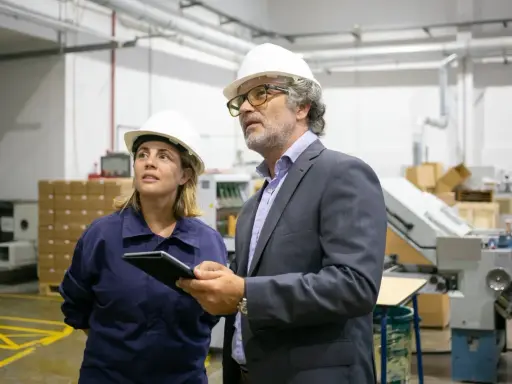 Supervisor de producción y su colega revisan el proceso en una fábrica.