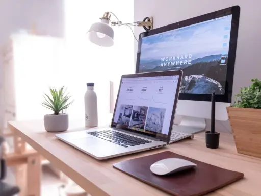 Escritorio moderno con laptop y monitor, ideal para un master business administration online.