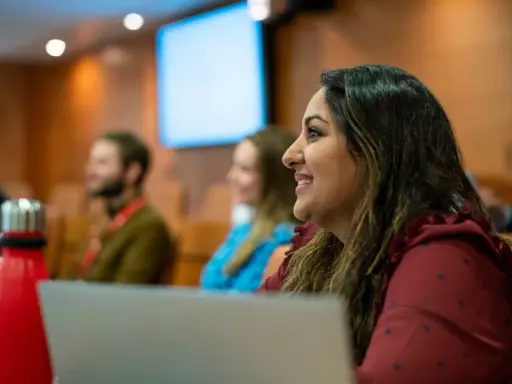 Mujer sonríe en clase del PDG IESE.