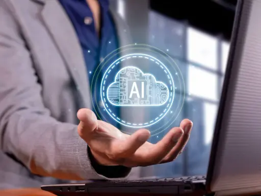 Un hombre con traje sostiene una nube digital con "AI" en su mano, representando los servicios en la nube para empresas.