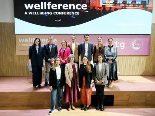 Grupo posa en el escenario de la conferencia "wellference", con el logo de ntp 639 visible.