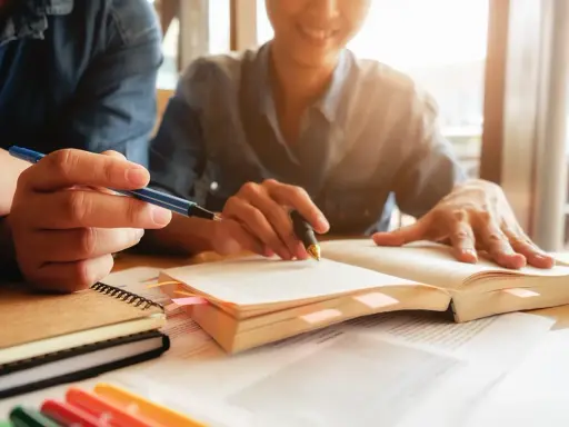 Estudiantes revisan apuntes y libros, preparándose para obtener becas MBA.