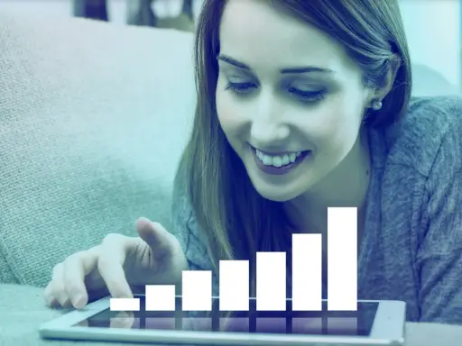 Mujer sonríe mientras interactúa con una tablet que muestra un gráfico de barras ascendente, simbolizando el liderazgo transformacional y el crecimiento.