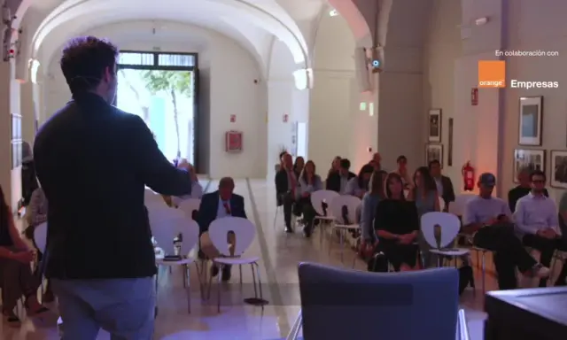 Ponente habla a audiencia en evento sobre empresas de inteligencia artificial, patrocinado por Orange Empresas.