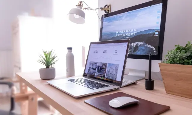 Escritorio moderno con laptop y monitor, ideal para un master business administration online.