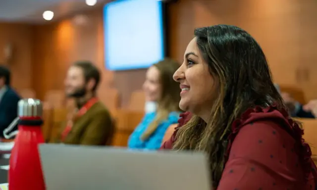 Mujer sonríe en clase del PDG IESE.