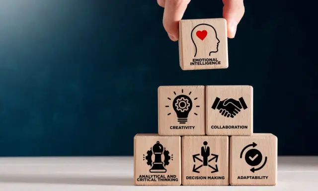 Bloques de madera apilados muestran habilidades blandas: inteligencia emocional, creatividad, colaboración, pensamiento analítico, toma de decisiones y adaptabilidad.