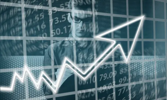 Hombre con gafas estudia un gráfico ascendente, simbolizando el progreso en un **part time MBA**.