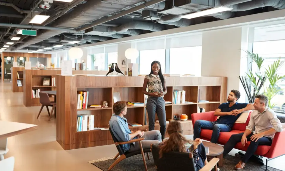 Un equipo diverso colabora en un espacio moderno y luminoso, creando un **ideal work environment**.