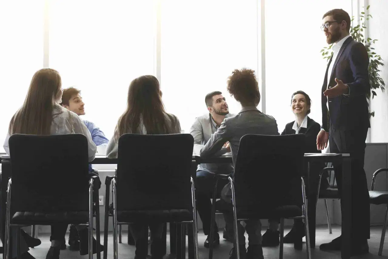 Un hombre con gafas da una charla a un equipo. Aprende cómo ser un CEO exitoso.