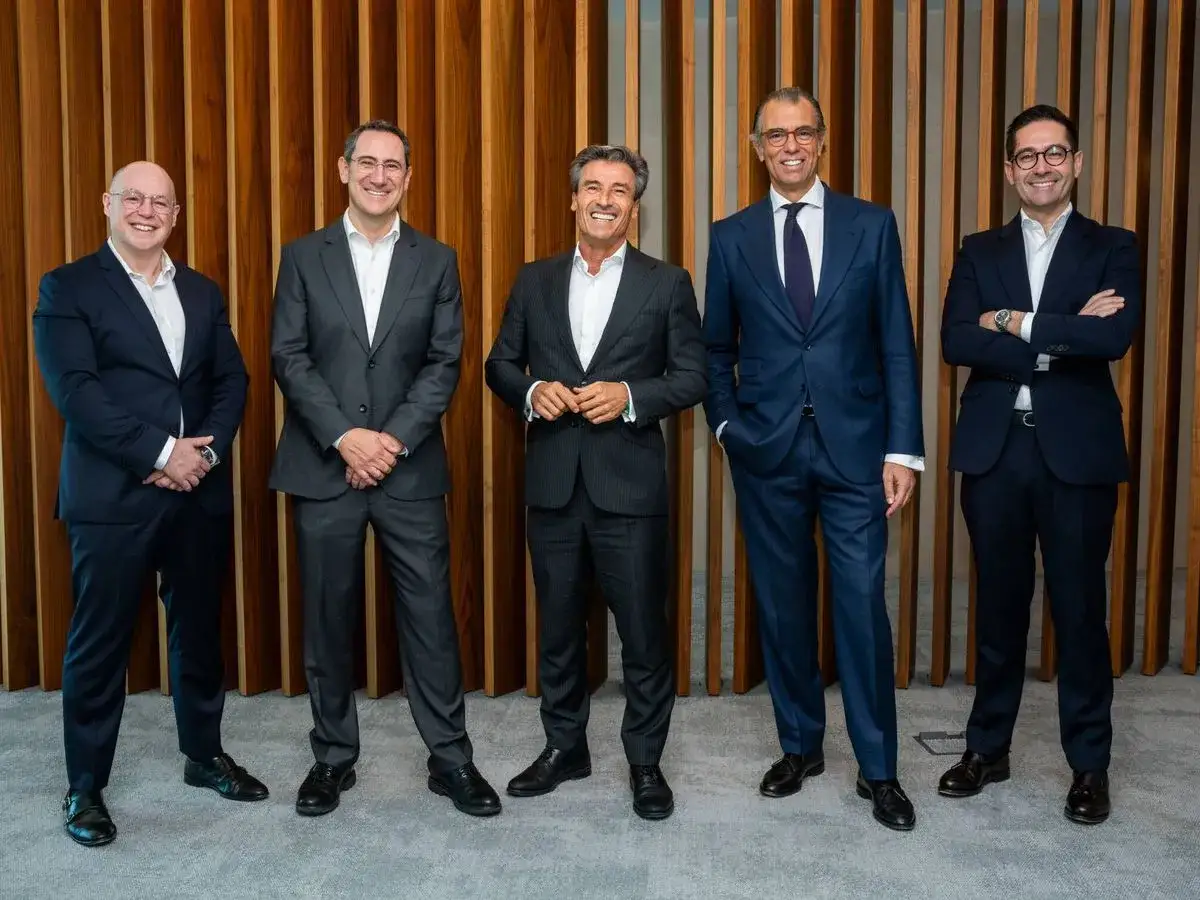 Cinco hombres de negocios con trajes elegantes, listos para impulsar negocios con inteligencia artificial.