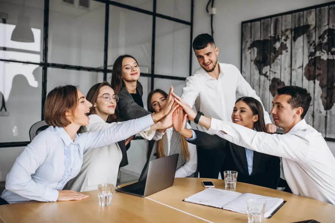 Equipo celebrando un éxito, mostrando las competencias de un líder: unidad, motivación y trabajo en equipo.