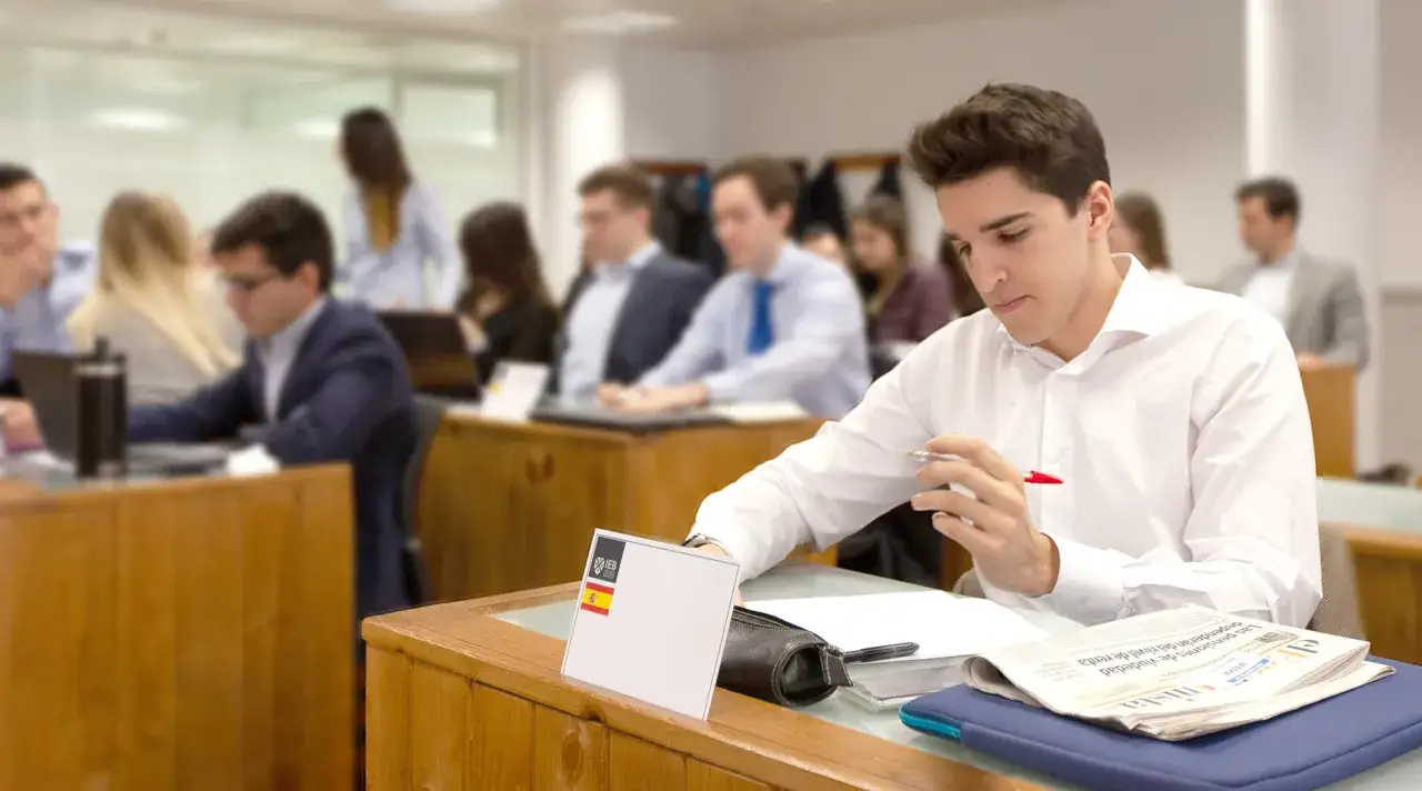 Estudiantes en un aula, uno enfocado en sus estudios de mba finanzas.