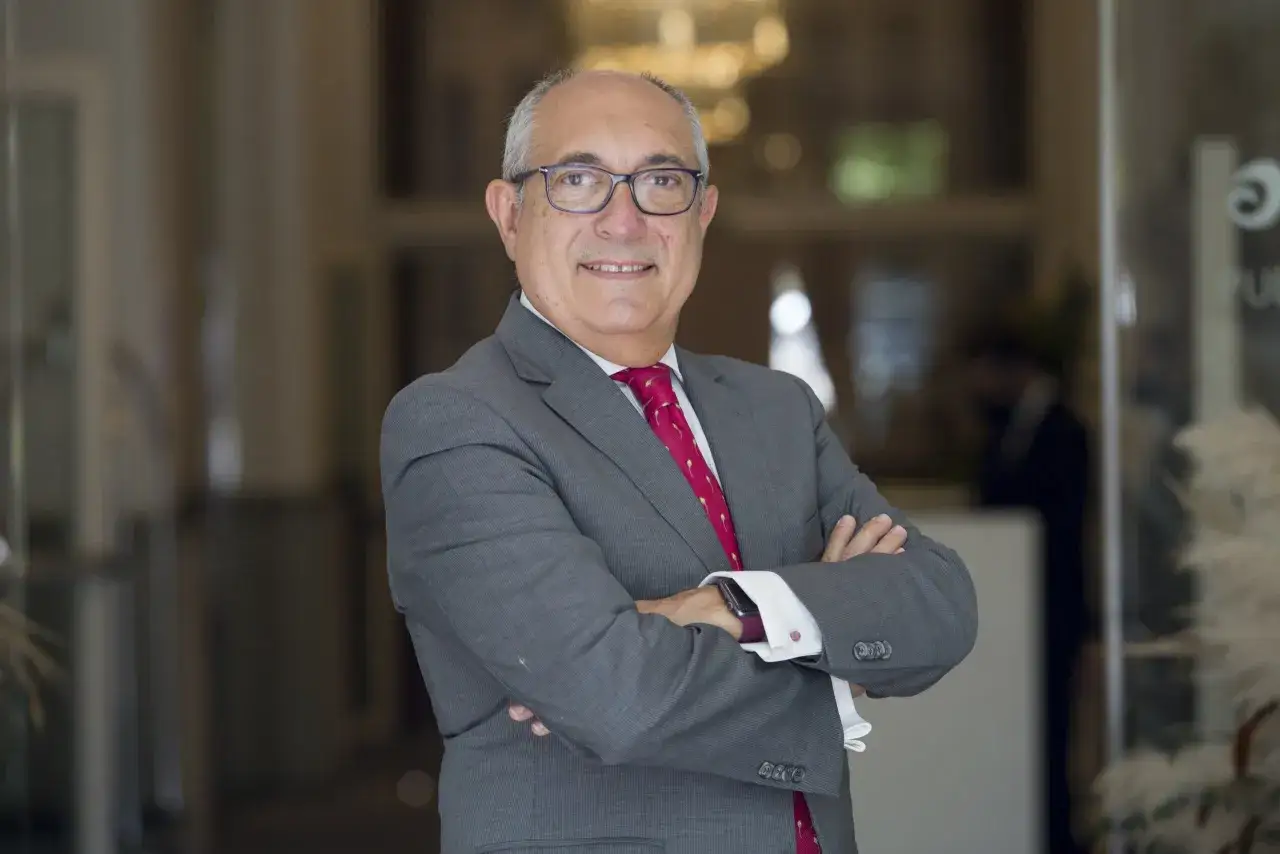 Hombre con traje gris y corbata roja, con los brazos cruzados. Posiblemente un participante en un advanced management program.