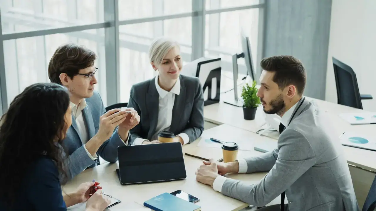 Equipo discutiendo ideas, demostrando excelentes habilidades de comunicaci&oacute;n empresarial.